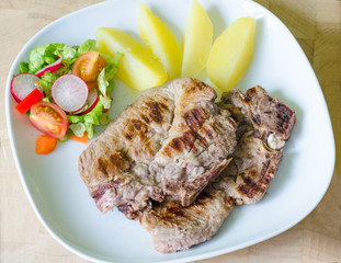 Pork steak with potatoes and salad