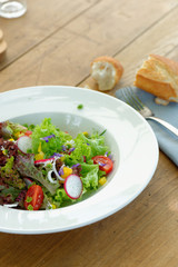 Fresh salad with tomatoes,cucumbers and bread baguete. green