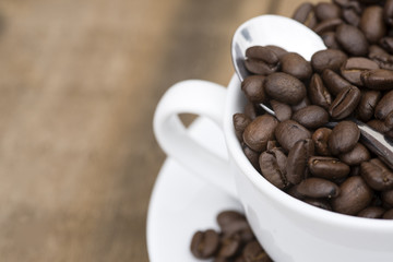 Cup of coffee and beans on wooden background