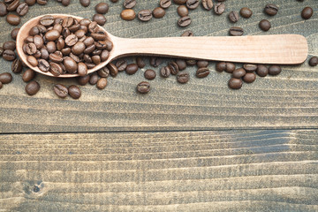 spoon full with coffee beans on wood