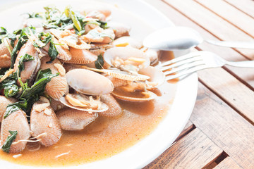 Stir fried clams with roasted chili paste on wooden table