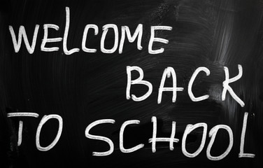 "Welcome back to school" handwritten with white chalk on a black