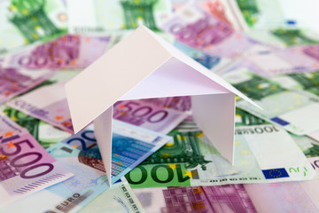Bargeld und Haus, symbolisieren Immobilienfinanzierung