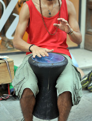Musicista di strada suona uno darbuka, strumento a percussione