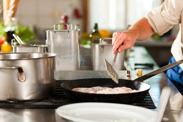 Obraz na płótnie Canvas Chef preparing fish in restaurant or hotel kitchen
