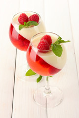 fruit jelly with raspberries in glasses on wooden table