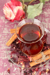 Herbal tea in glass cup, on color wooden background