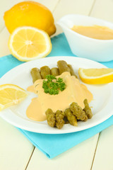 Asparagus on plate, on wooden background