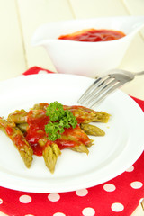 Asparagus on plate, on wooden background