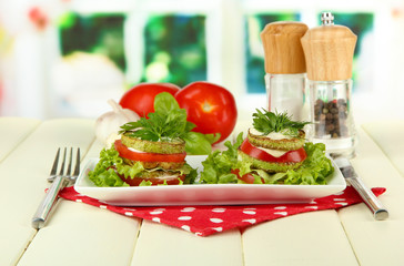 Tasty roasted marrow and tomato slices with salad leaves,