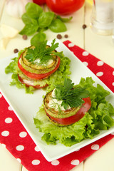 Tasty roasted marrow and tomato slices with salad leaves,