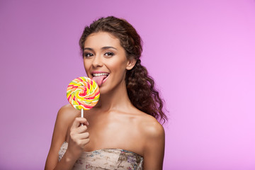 Eating a lollipop. Beautiful young women eating lollipop while s