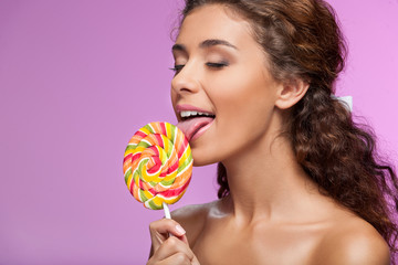 Licking the lollipop. Portrait of Beautiful young women licking