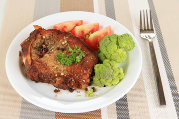 Piece of fried meat on plate on napkin close-up