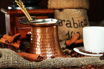 Metal turk and coffee cup on dark background