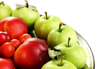 Assortment of juicy fruits on plate, isolated on white