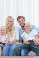 Family sitting on couch playing video games