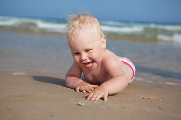 Little girl lying on sand at beach