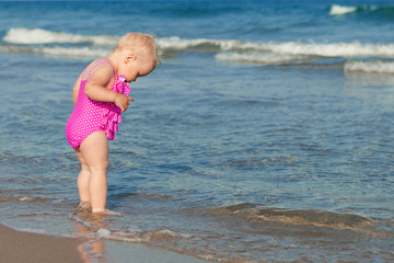 Adorable girl walking along beach