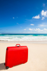 red suitcase at the beach