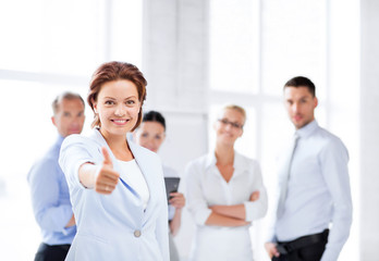 businesswoman in office showing thumbs up