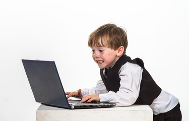 Freckled red-hair little boy with laptop.