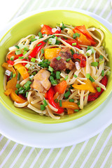 Noodles with vegetables on plate on napkin close-up