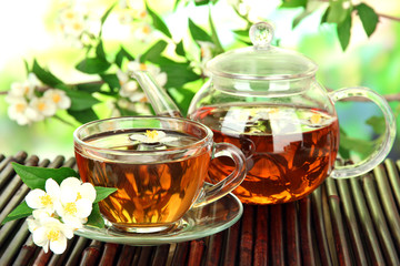 Cup of tea with jasmine, on bamboo mat, close-up
