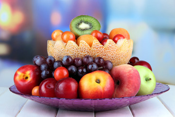 Obraz na płótnie Canvas Assortment of juicy fruits on wooden table, on bright