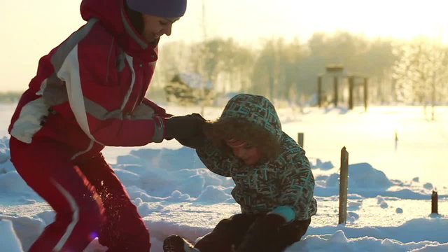 Young mother helps the child to get out of a snowdrift