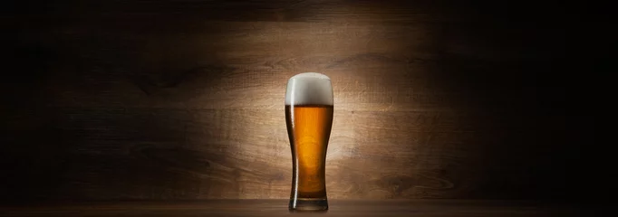 Fotobehang Bier glas bier op hout achtergrond met copyspace