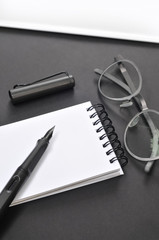 Fototapeta premium Eye glasses, blank notepad, and pen, on the table