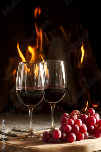 Copas de vino uvas y fuego en chimenea de fondo." fotos de archivo ...