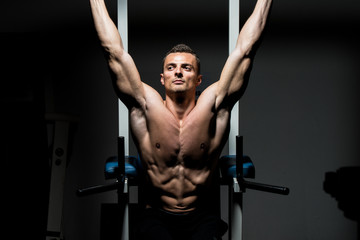 Fototapeta na wymiar handsome man exercising his abs at the gym