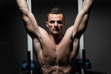 Fototapeta na wymiar Handsome Man Exercising His Abs At The Gym