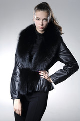 Portrait of a beautiful young woman with fur coat in studio