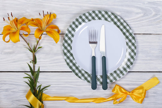 Fototapeta A lovely table setting decorated with yellow lily with a ribbon.
