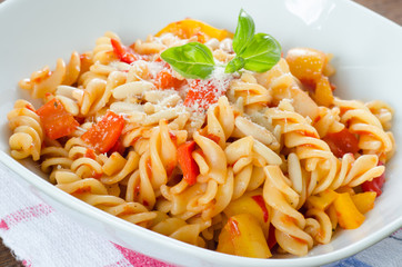 Close up on a dish of fresh pasta with tomato, pepper and cheese
