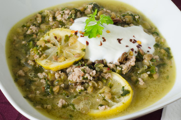 Close up on a dish of lentil stew with minced meat and lemon