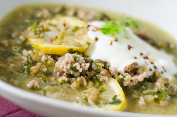 Close up on a dish of lentil stew with minced meat and lemon