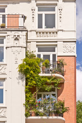 Fototapeta na wymiar Obsadzone balkony na pięknym, starym budynku z sztukaterie