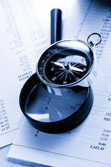 Operating budget, magnifying glass and black compass
