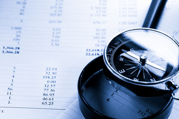 Operating budget, magnifying glass and black compass