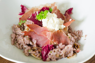 Red wine risotto with fried ham and salad