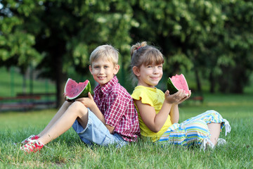 Fototapeta premium boy and little girl eat watermelon