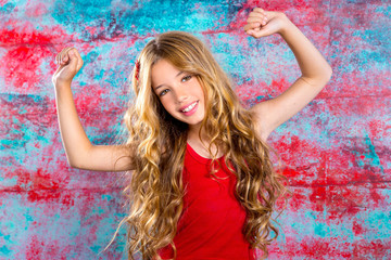 Blond happy children girl in red happy arms up