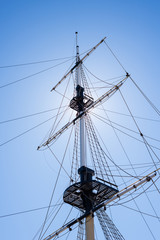 Mast of the sail boat on the blue sky background with sunlight