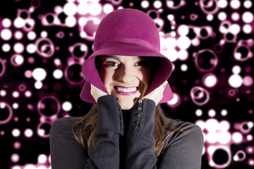 Portrait of young girl with a hat in front of spotlights backgro