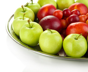 Assortment of juicy fruits on plate, isolated on white