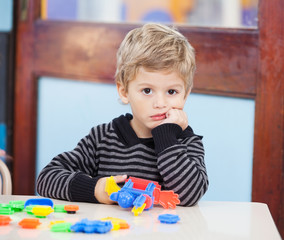 Unhappy Boy With Blocks In Classroom